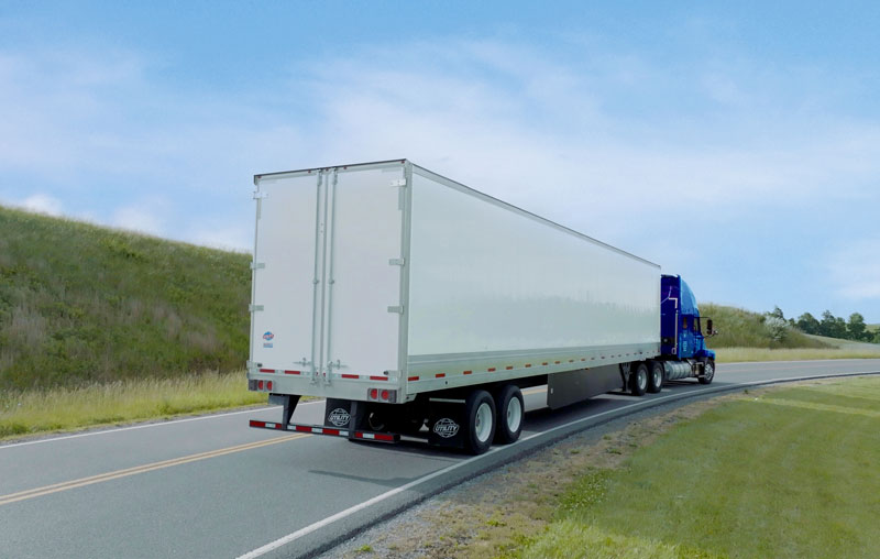A large dry van logistics trailer on the road
