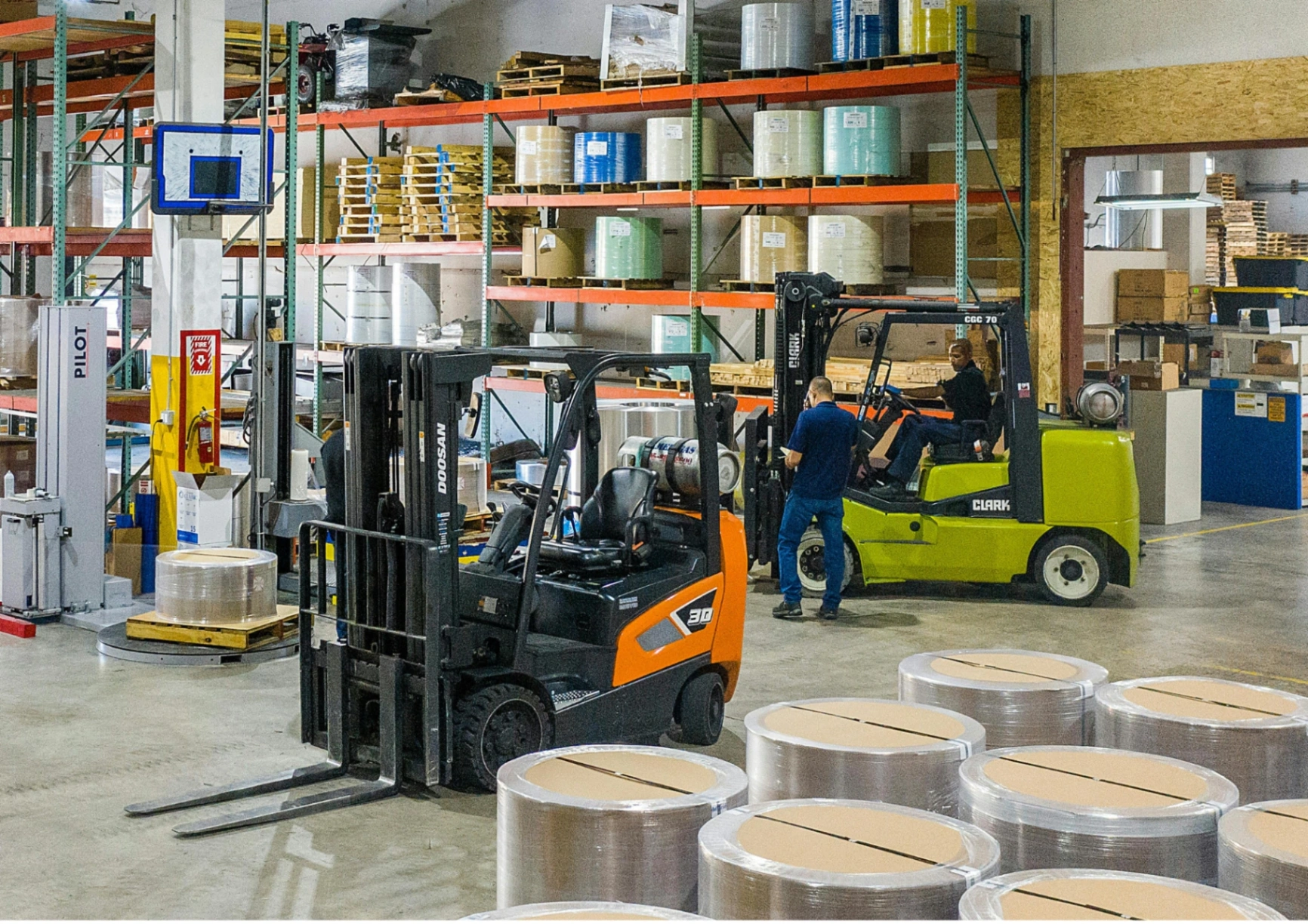 A forklift loading pallets in a busy cross docking warehouse